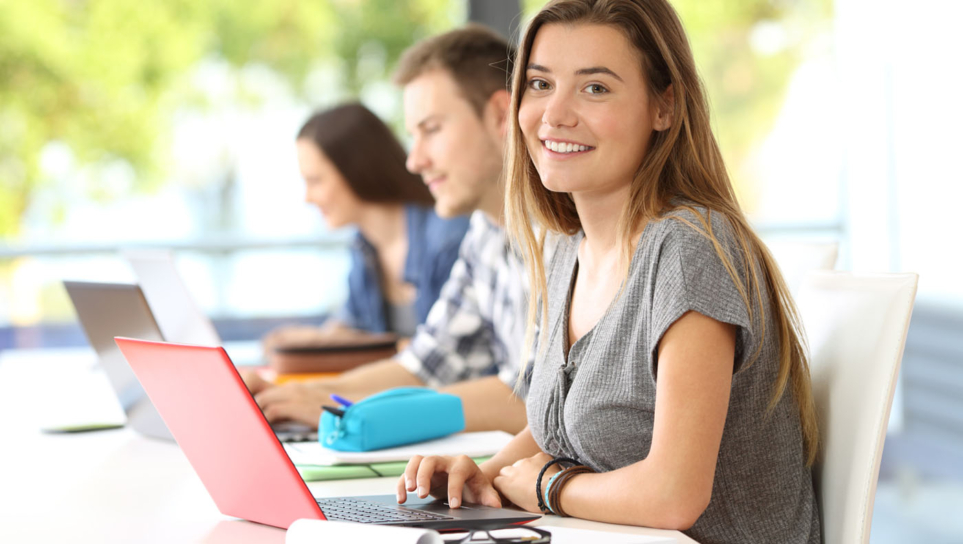 Alumnos y alumnas frente a sus laptops.